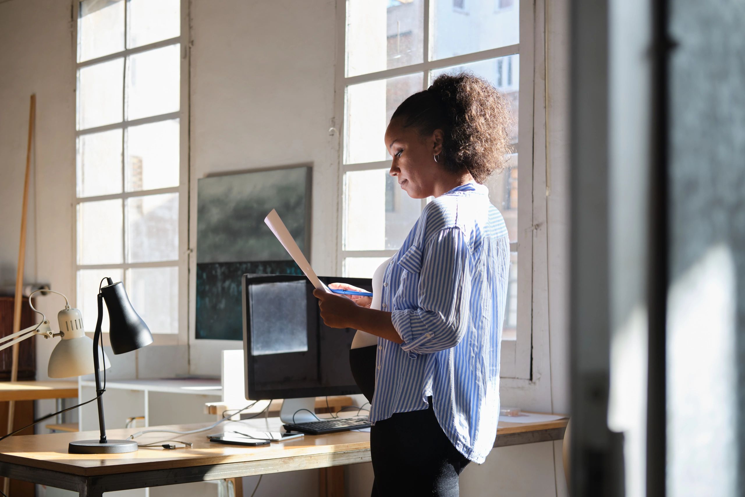 Black female consultant reviewing documents in a modern office